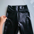 Black faux leather pants have their waistband displayed - Fleece Chic
